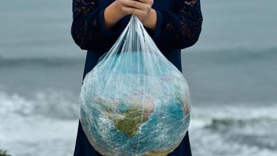 Grafika do poradnika: Ekologia wokół nas. Globus - kula Ziemska owinięta w foliowe torebki fot. Pexels Nick Bondarev
