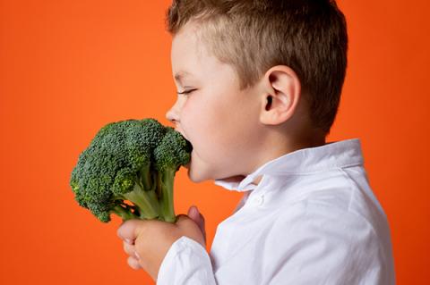 Grafika do informatora: Zdrowe odżywianie się domu i w szkole. Chłopiec je brokuła. fot. pexels