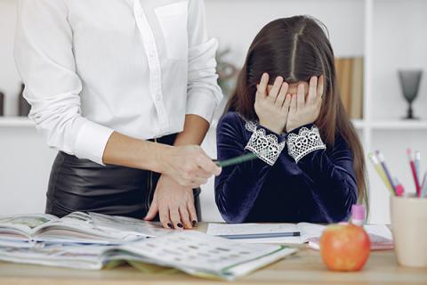 Grafika do poradnika: O stresie. Dziewczynka przy lekcjach zakrywa dłońmi twarz. fot Pexels Gustavo Fring