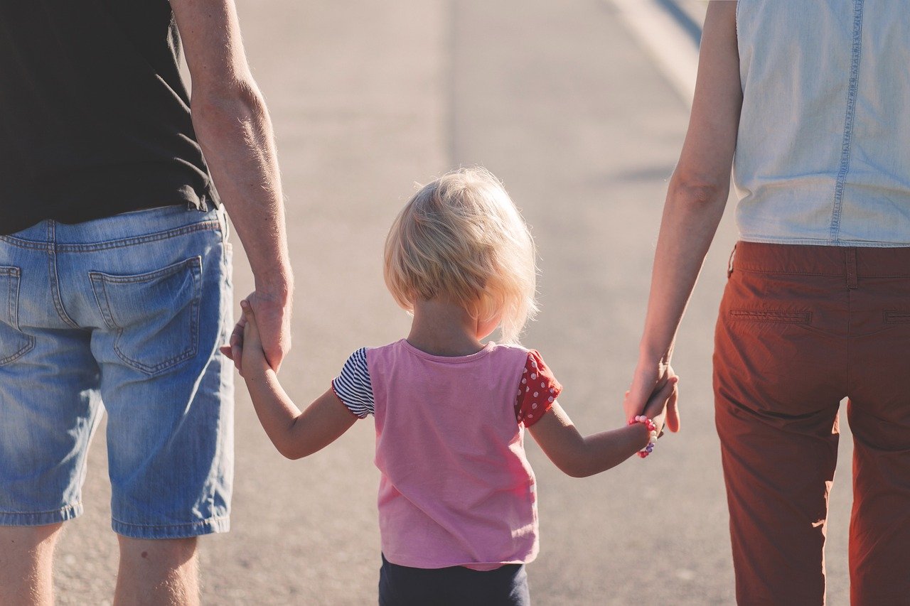 Fotografia przedstawiająca rodziców z dzieckiem na spacerze